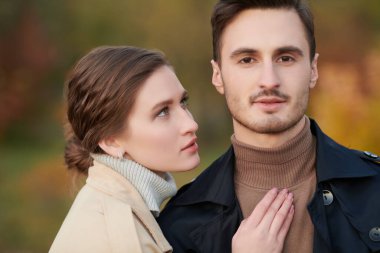 Aşık insanlar. Güzel bir genç kadın ve şık sonbahar kıyafetleri giymiş yakışıklı bir adamın portresi. Sonbahar parkı arkaplanı. 