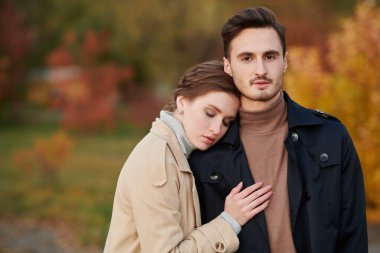 Aşık insanlar. Güzel bir genç kadın ve şık sonbahar kıyafetleri giymiş yakışıklı bir adamın portresi. Sonbahar parkı arkaplanı. 