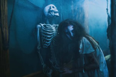 Saplantılı lanet kadın. Kana susamış bir zombi kadın iskeleti ve örümcek ağıyla terk edilmiş eski bir evde dolaşıyor. Korku, gerilim. Cadılar Bayramı.