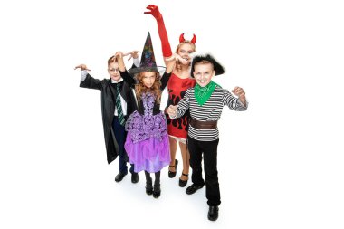 Cadılar Bayramı kostümlü bir grup neşeli çocuk yaklaşıyor ve eğlenmekten korkuyorlar. Beyaz arkaplanda tam boy portre.
