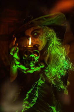 Korkunç hikayeler. Korkunç çirkin bir cadı elinde mumla terk edilmiş bir cadının ininde duruyor. Cadılar Bayramı. 