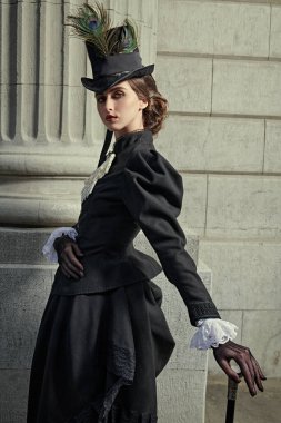 Şehir caddesinde poz veren zarif bir 19. yüzyıl kadını. 19. yüzyılın sonları - 20. yüzyıl başları. 