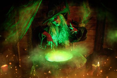 Korkunç yaşlı cadı, sihirli ışıkla çevrili kazanında büyücülük yapıyor. Cadılar Bayramı. Korkunç hikayeler..