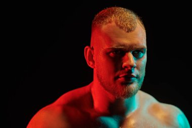 Siyah arka planda çıplak gövdeli güçlü ve kendine güvenen bir haltercinin portresi. Profesyonel spor, şampiyon. Siyah arka plan. Yakın çekim..