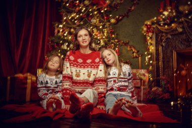 Güzel anne ve güzel kızları Noel arifesinde Noel arifesini Noel ağacının yanında oturarak geçirirler. Mutlu Noeller aile.. 
