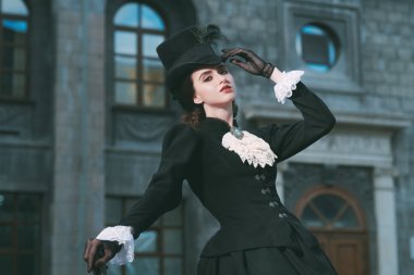 Şehir caddesinde poz veren zarif bir 19. yüzyıl kadını. 19. yüzyılın sonları - 20. yüzyıl başları. 