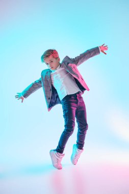 Profesyonel hip hop ve break dansçı çocuk stüdyoda beyaz arka planda karışık renkli ışıkta dans ediyor. Çağdaş danslar. Tam boy portre. 