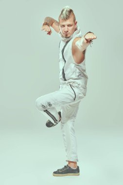 Kollarını kaplayan dövmeleri olan havalı sarışın punk müzisyeninin portresi stüdyo arka planında kendini ifade ediyor. Siber punk stili. 