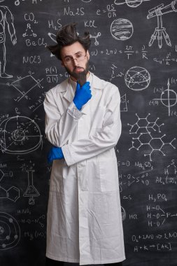 Takıntılı bir profesör elinde bilimsel formüllerle tahtada duruyor ve yeni fikrini düşünüyor.. 