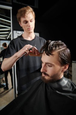 Koyu renk saçlı yakışıklı genç adam kuaför salonunu ziyaret ediyor. Berber Dükkanı. 