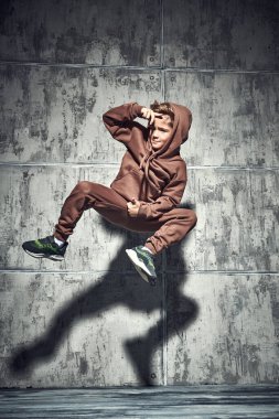 Havalı bir çocuk stüdyoda homurdanarak coşkuyla break dans yapıyor. Tam boy portre. Spor ve aktif yaşam tarzı. Modern danslar. 