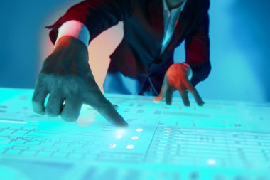 Modern sanal teknolojiler. İş konsepti. Takım elbiseli bir adam sanal bir ekrana holografik çizelgeler ve diyagramlarla dokunuyor.. 