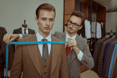 Başarılı genç işadamı, kaliteli erkek giyim mağazasında terzilik hizmeti alıyor. Erkeklerin iş modası. 
