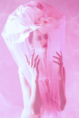 Kafasında büyük bir şakayık çiçeği olan, pembe arka planda şeffaf organzayla kaplanmış oldukça şehvetli bir kız. Kozmetik ve parfüm. Deri ve vücut bakımı.