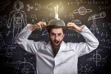 Zeki bir eksantrik bilim adamı elinde bilimsel formüller ve kafasında garip bir buluş olan diyagramlarla tahtada duruyor ve gülümsüyor. Bilim ve yeni icatlar.