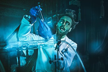 Ele geçirilmiş bir bilim adamı gizemli bir mavi ışıkla laboratuarında deneyler yapıyor. Bir bilim kurgu romanının karakteri. 