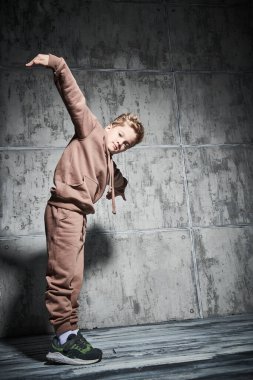 Stüdyoda homurdanarak break dans yapan genç bir çocuk. Spor ve aktif yaşam tarzı. Tam boy portre. Modern danslar. 