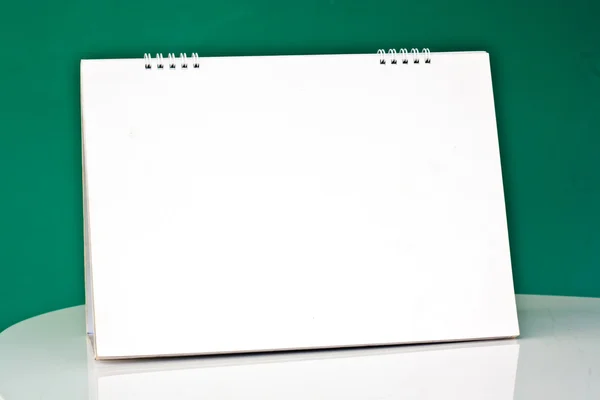 Blank desktop calendar on the table in the office green backgrou — Stock Photo, Image