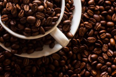 ahşap zemin üzerinde beyaz fincan kavrulmuş kahve çekirdeği