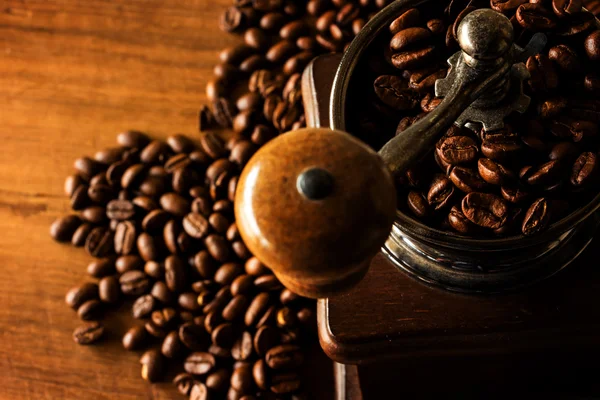 Antique coffee grinder with coffee beans in the blurred backgrou — Stock Photo, Image
