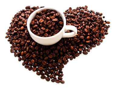 Kalp şeklindeki kavrulmuş kahve çekirdekleri ile beyaz fincan