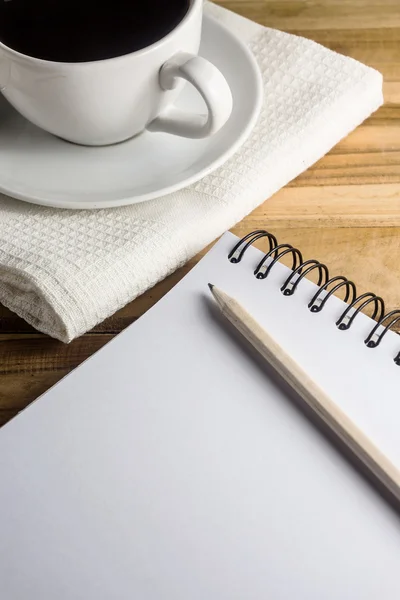 Mesa de trabalho com papel, lápis e xícara branca de café — Fotografia de Stock