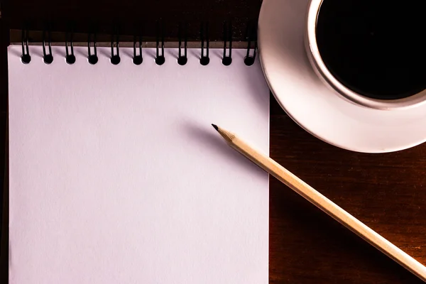 Ouvrez un carnet blanc vierge, un crayon et une tasse de café sur les des — Photo