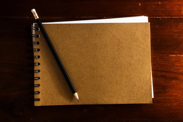 Старая винтажная записная книжка с ручкой на деревянном столе — стоковое фото