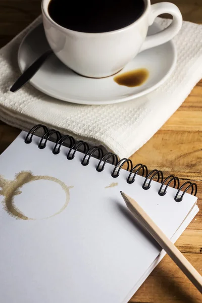 Paper, pencil and white cup of coffee on desk — Stock Photo, Image