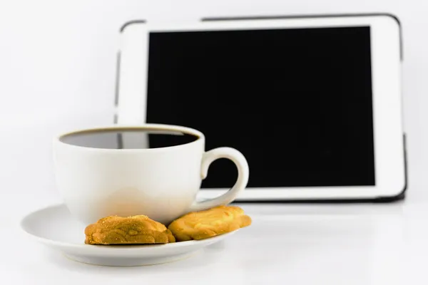 Cup of coffee with cookie and tablet computer isolated on white — Stock Photo, Image