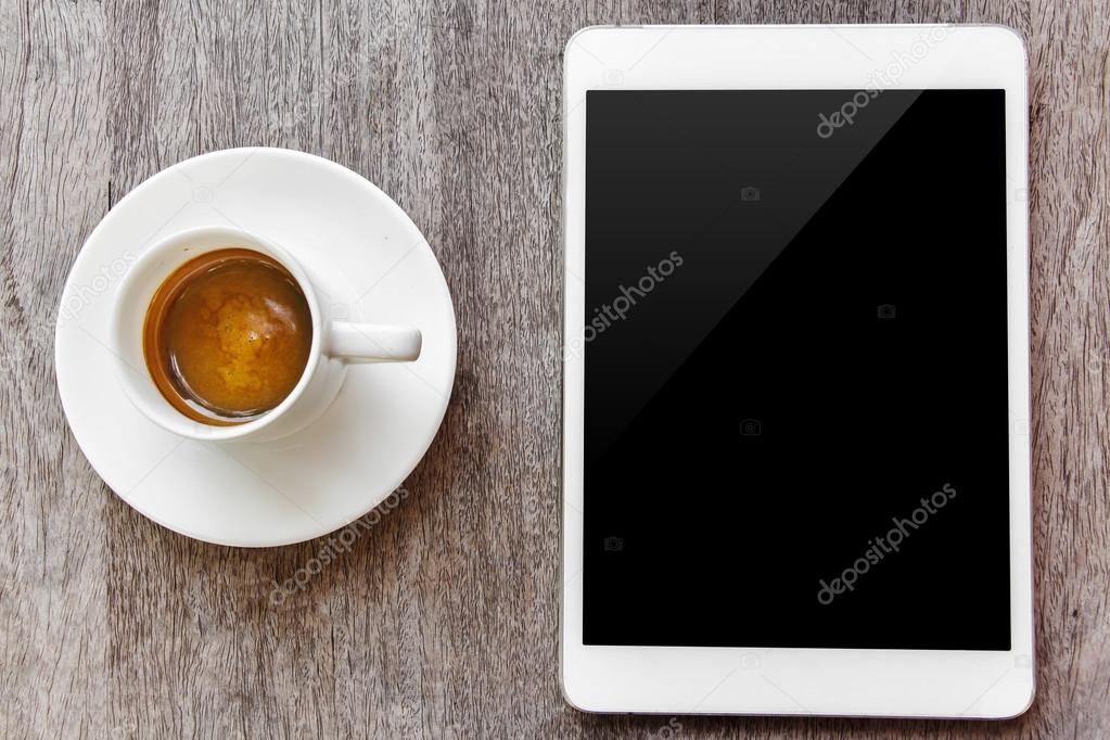 digital white tablet and coffee cup on wooden table