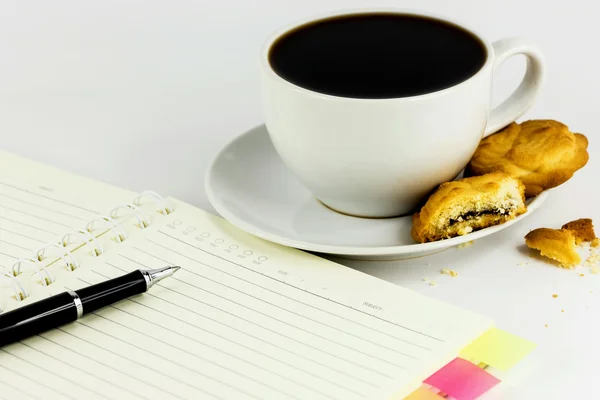 Xícara de café, biscoitos, notebook e caneta isolada no backgro branco — Fotografia de Stock