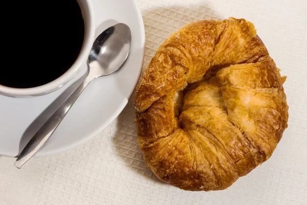 Káva a croissant na dřevěném stole — Stock fotografie