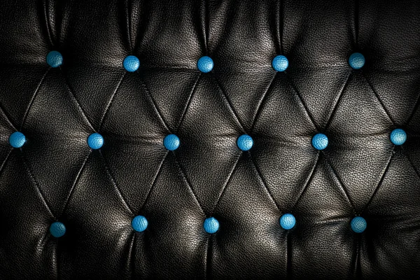 Abstraktes schwarzes Leder vor blauem Hintergrund — Stockfoto
