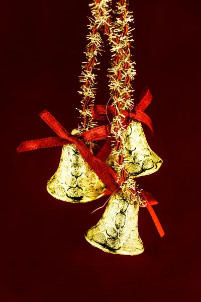 Festlig klockor med jul holly på röd bakgrund — Stockfoto