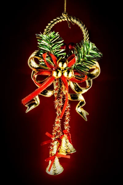 Świąteczne dzwonki z holly Boże Narodzenie na czerwonym tle — Zdjęcie stockowe