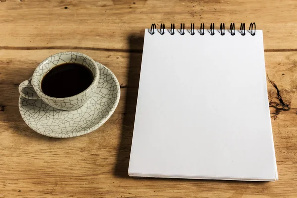 Schetsboek en onmiddellijke coffeeagainst hout achtergrond — Stockfoto