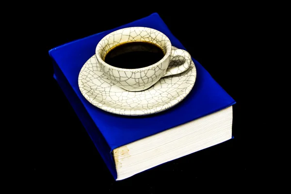 Taza de café y libro aislado sobre fondo negro . — Foto de Stock