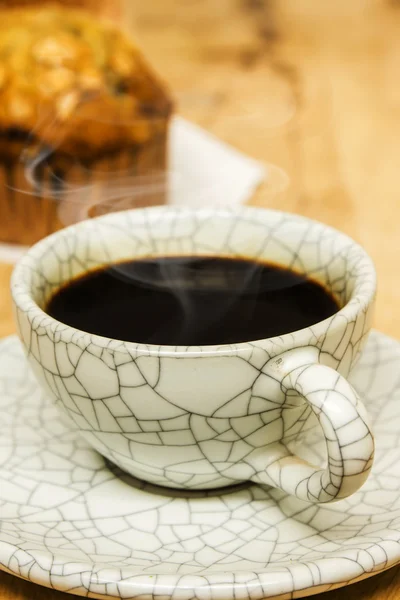 Amandel muffins met koffiekopje op houten tafel — Stockfoto