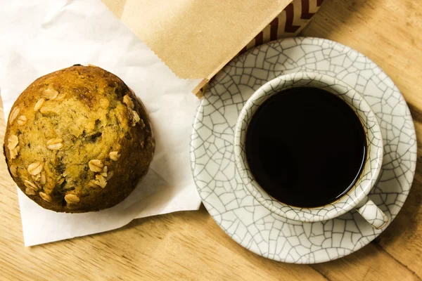 Muffin alle mandorle con tazza di caffè sul tavolo in legno, vista dall'alto . — Foto Stock