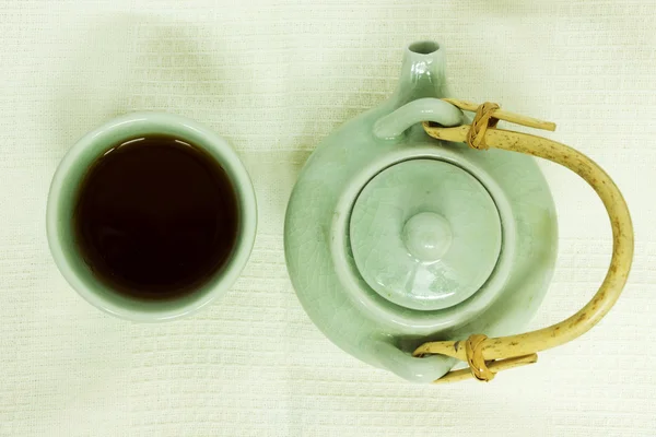 Filiżanka herbaty z czajnik na białym obrusem. — Zdjęcie stockowe
