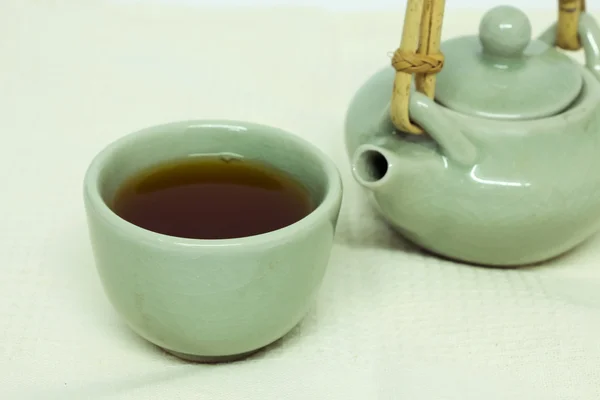 Tasse Tee mit Teekanne auf weißer Tischdecke. — Stockfoto