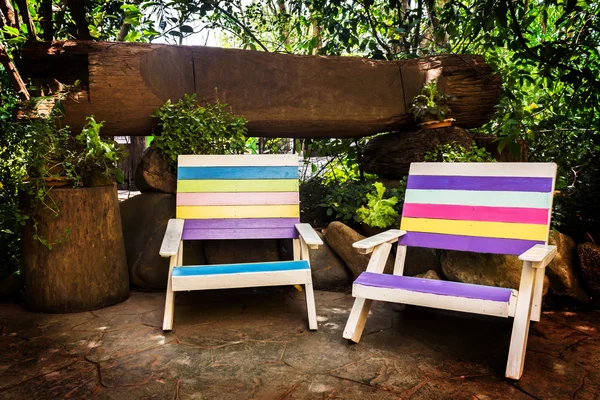 colorful wooden lawn chairs in the spring garden.