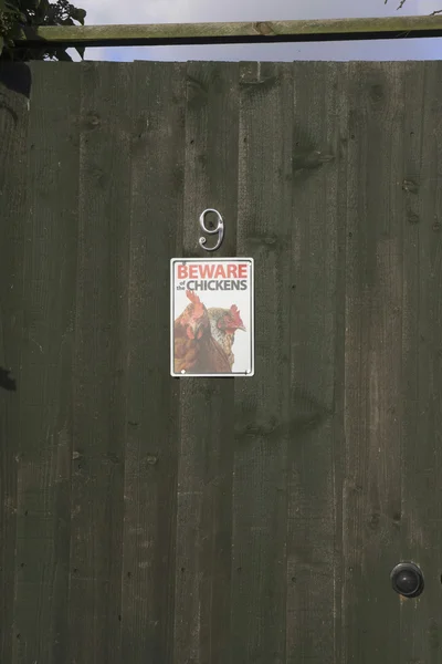 Wood door with beware chikens sign — Stock Photo, Image