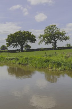 A canal on the inland waterways network of navigable canals and waterways in the english and british countryside in the uk, united kingdom, great britain, europe clipart