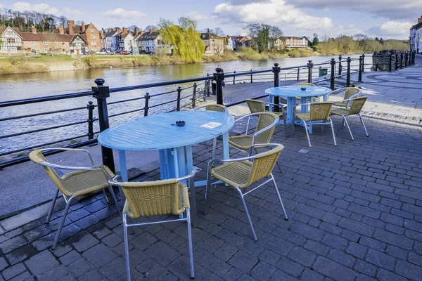 Blue tables and yellow chairs on the waterfront — Stock Photo, Image