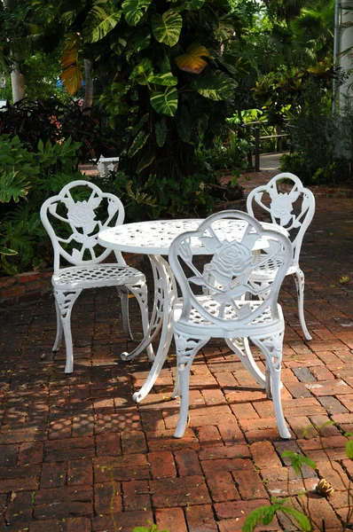 White garden chairs in a backyard patio