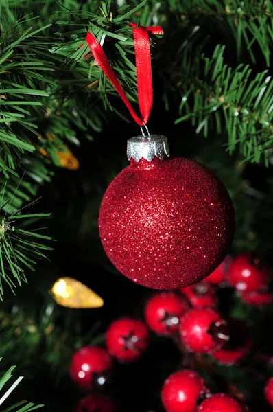 Red glitter holiday ornament and berries — Stock Photo, Image
