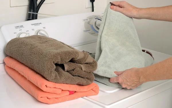 Folding clean towels and laundry — Stock Photo, Image