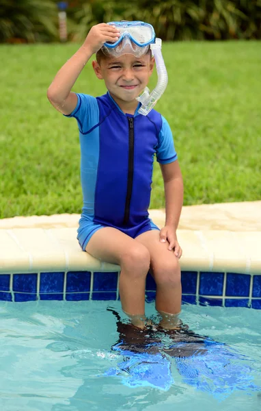 Lindo niño sentado en el borde de la piscina —  Fotos de Stock